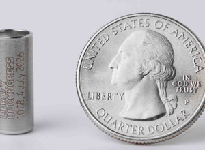 A one gigabyte synthetic DNA storage vial encoded with digital copies of Library collection items alongside a quarter 