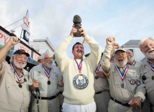 Surrounded by previous winners of the Hemingway Look-Alike Contest, 2026 champion Chris Dutton hoists his trophy, a bronze bust of Nobel Prize-winning author Ernest Hemingway, outside Sloppy Joe’s Bar.
