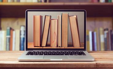 row of books on laptop monitor
