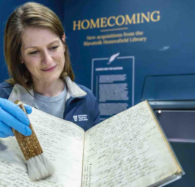 Suzanne Reid, Regional Conservator for the National Trust for Scotland inspects the First Commonplace Book